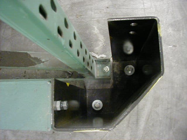 Detail van de voet en verankering van een stellingstaander op een betonvloer