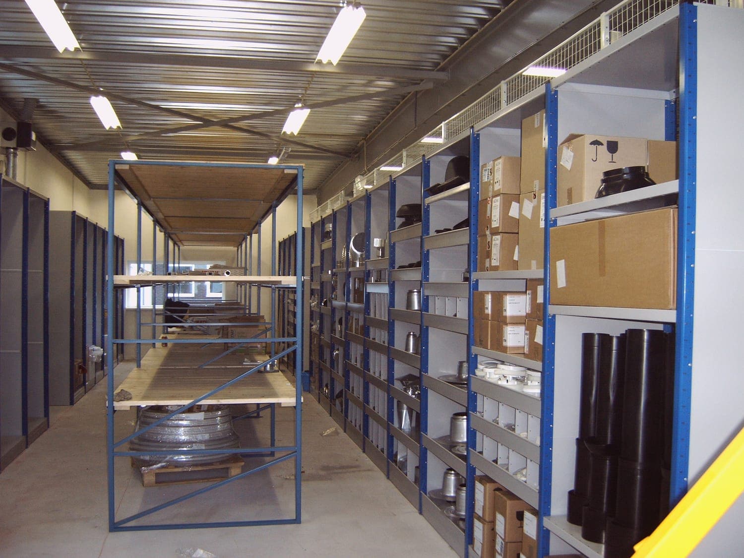 Legbordstelling met legborden en blauwe staanders in een magazijn