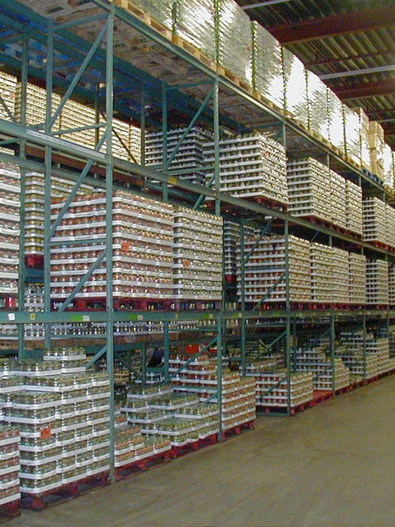 Volgeladen palletstellingen in een magazijn die jaarlijks op veiligheid worden gecontroleerd