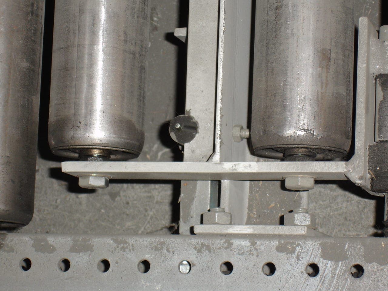 Detail van de stalen rollen in de rollenbaan van een doorrolstelling, met de boutverbinding waarmee de baan op de dragende constructie ligt